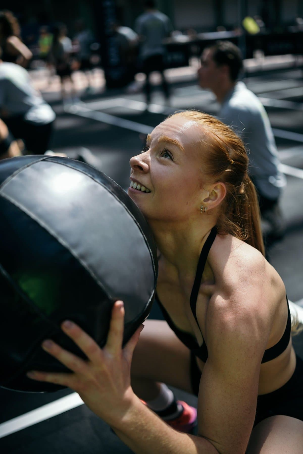 Nolwenn sourit en plein effort, un medicine ball contre l'épaule